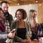 Friends at Balderdash Cellars enjoying glasses of wine, smiling and happy